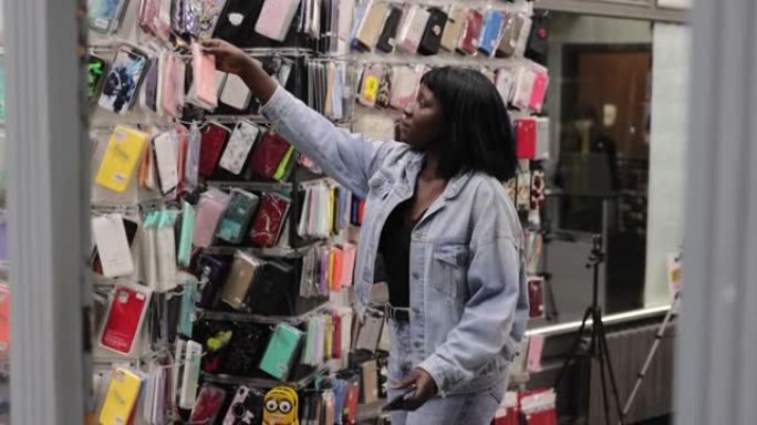 年轻的非洲女性在商店购物智能手机外壳