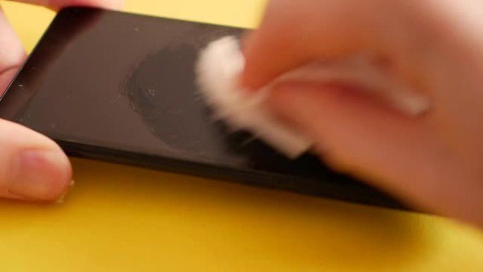 细菌特写对智能手机屏幕的抗菌处理。在更换之前，请清洁移动设备的触摸屏上的灰尘。用抹布清洁手机表面。