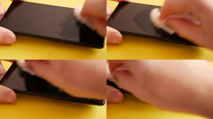 细菌特写对智能手机屏幕的抗菌处理。在更换之前，请清洁移动设备的触摸屏上的灰尘。用抹布清洁手机表面。