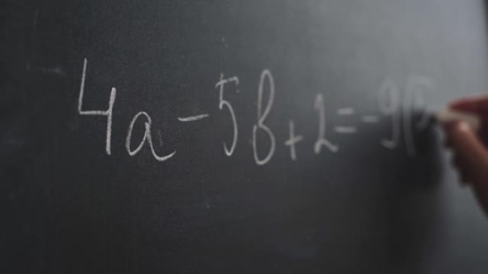 女人用粉笔的手在黑板上写公式