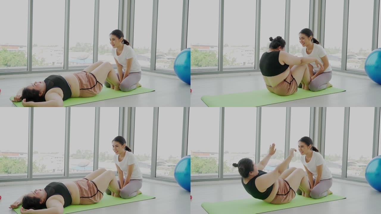 女子健身教练教肥胖妇女仰卧起坐运动减肥