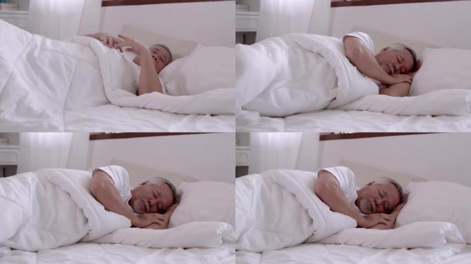 亚洲老人在床上睡觉和甜蜜的梦。