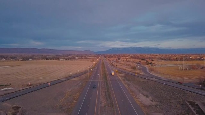 日落时在科罗拉多州大章克申附近的70号州际公路上行驶的车辆和半卡车的空中拍摄