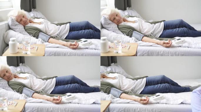 退休年龄的妇女躺在床上，手臂上放着血压计，血压升高了