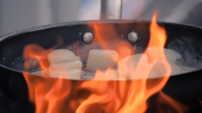 慢动作: 美食节上在锅上烹饪扇贝肉的过程