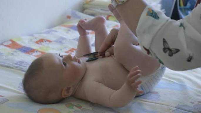 婴儿在新型冠状病毒肺炎大流行的儿科医生办公室。医生为新生儿接种疫苗，特写。