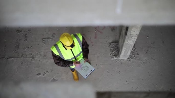 一位建筑师-一位戴着防护背心的防护头盔的工程师会审查装饰旧办公楼的项目。致力于建筑改造和投资估算。