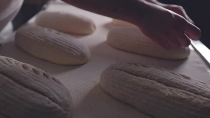面包师用刀在生面包上制作图案，慢动作4k视频