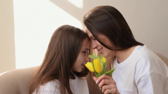 一位黑发少女送给母亲一束黄色郁金香。母亲节，3月8日和生日的概念。