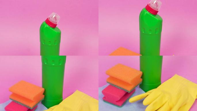 在粉红色的背景上，一瓶清洁剂，海绵和清洁布。