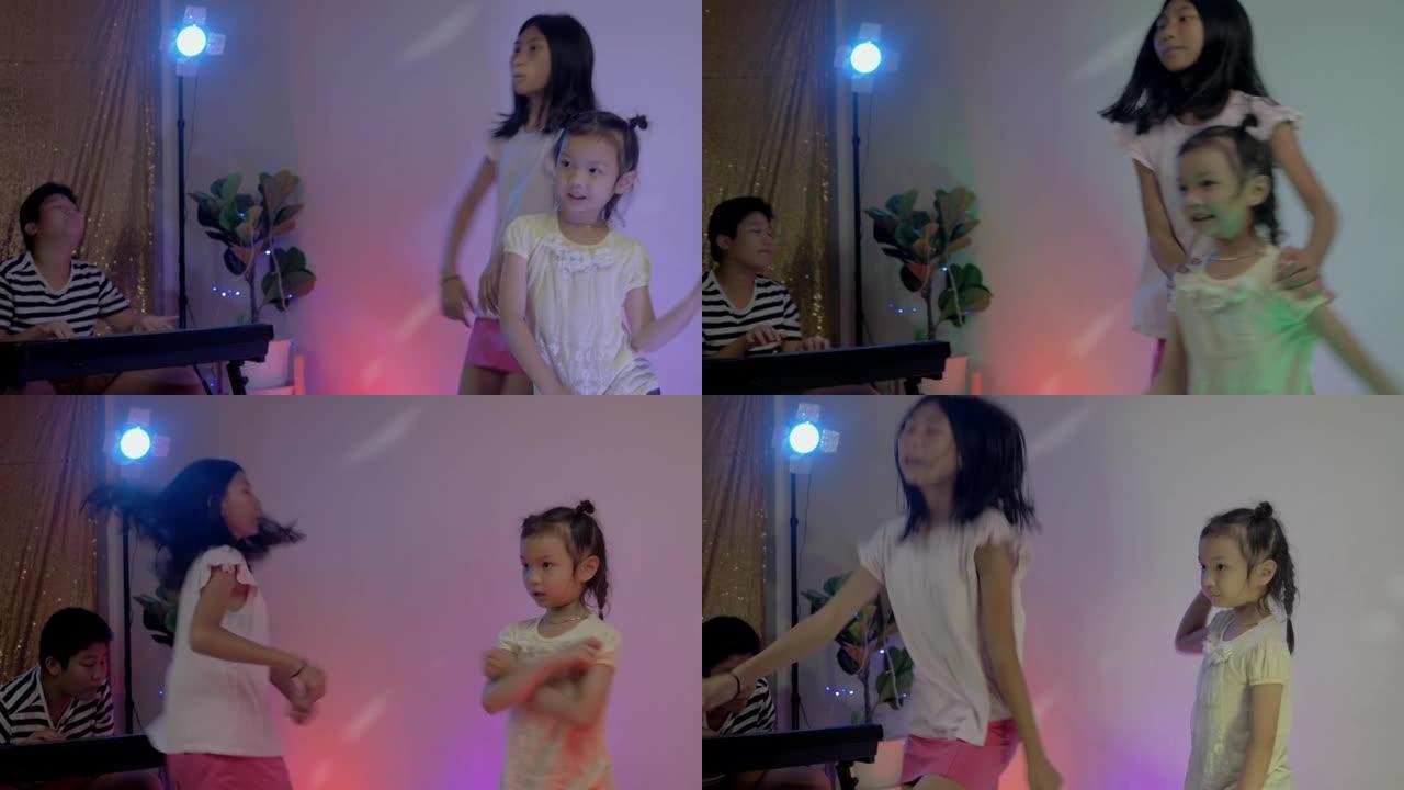 快乐的亚洲儿童在家跳舞，带发光二极管背景，在家聚会的概念。