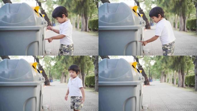 可爱的小男孩把干净的垃圾放在垃圾箱里