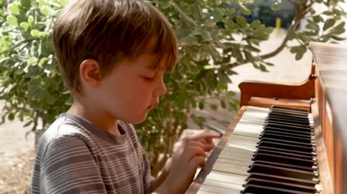 小男孩在户外玩钢琴