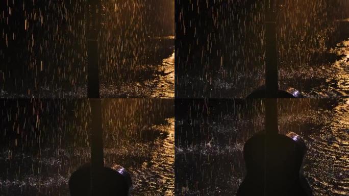 雨中木制原声吉他的详细镜头。在黑色的录音室背景上，吉他表面的水鼓在不同的方向上散射。特写。慢动作