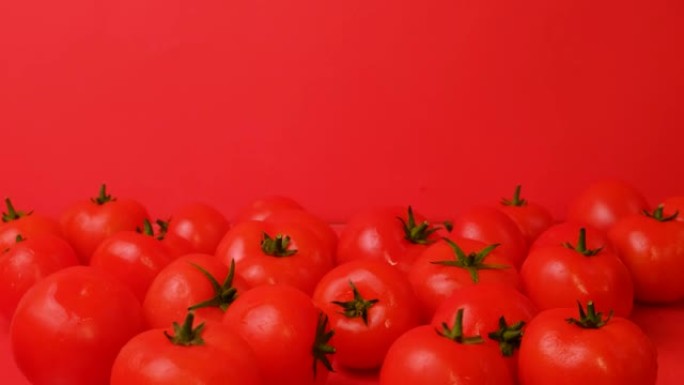 几个西红柿落在红色背景上的一堆蔬菜上。一座山西红柿分崩离析