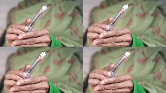 老年女性手持胰岛素笔，有复印空间，