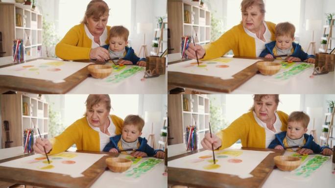 祖母和她的小孙子在家画画