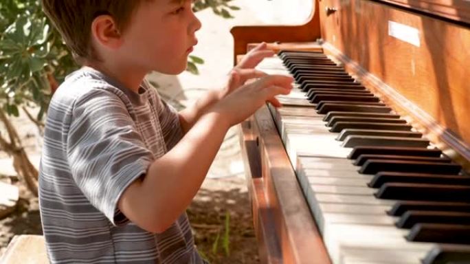 小男孩在户外玩钢琴