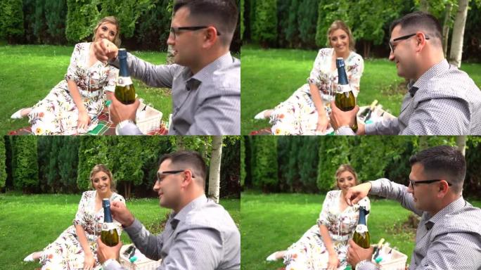 男子与妻子在浪漫野餐中开香槟