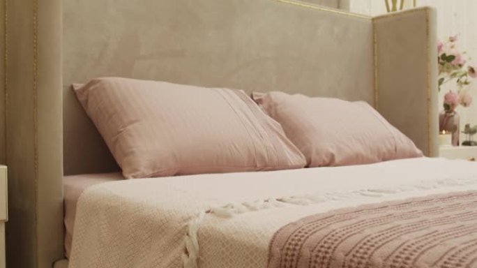 奶油-粉色枕头和同样颜色的纺织品封面的特写镜头