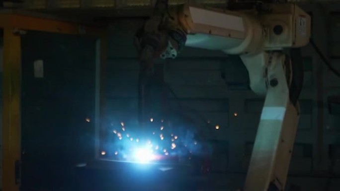 在工业工厂中，机械臂发出的火花正在焊接。