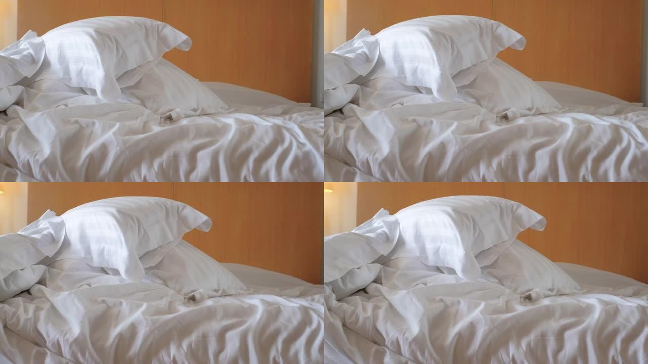 卧室床上的特写折痕白色毯子。不干净的酒店床