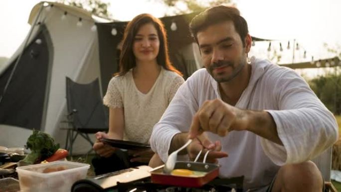 爱情情侣烹饪食物露营之旅休闲冒险，度假时一起煎蛋。