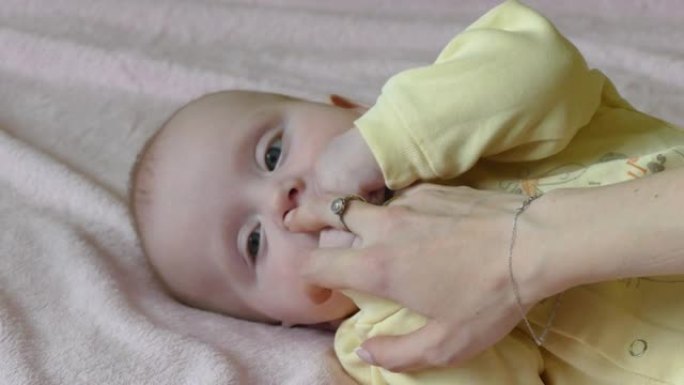 婴儿玩妈妈的手指混血儿婴儿吃妈妈的手指
