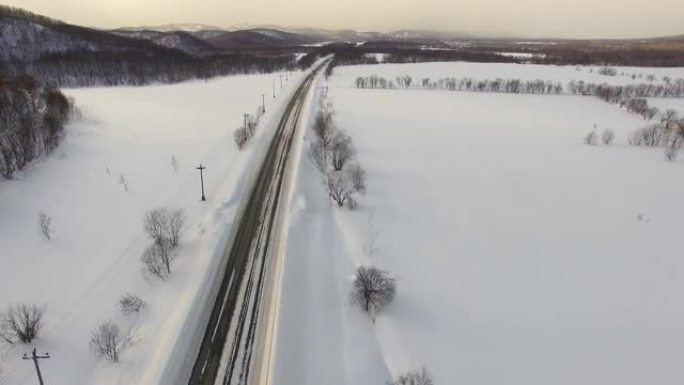 无人机摄像头显示下雪时交通中的汽车。在背景领域，道路。