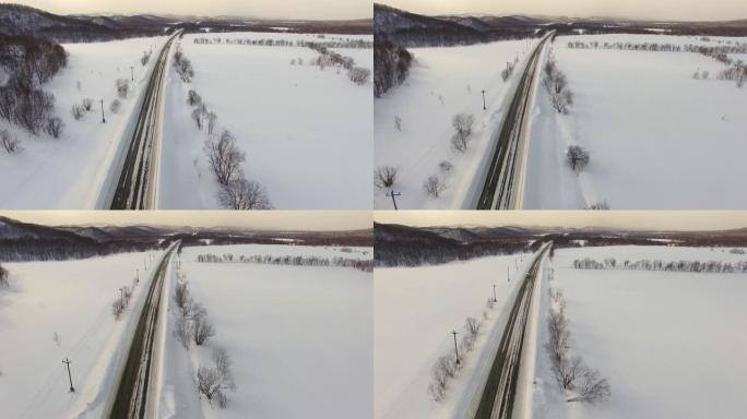 无人机摄像头显示下雪时交通中的汽车。在背景领域，道路。