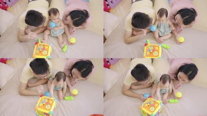 顶视图-亚洲父母在女儿玩玩具时照顾她