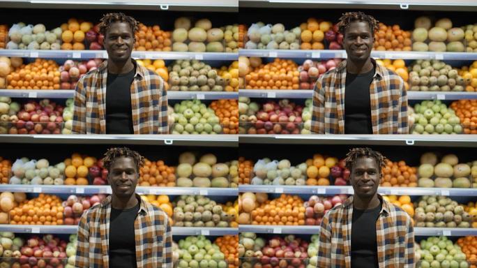 非裔美国英俊的年轻人在超市里看着相机微笑的肖像