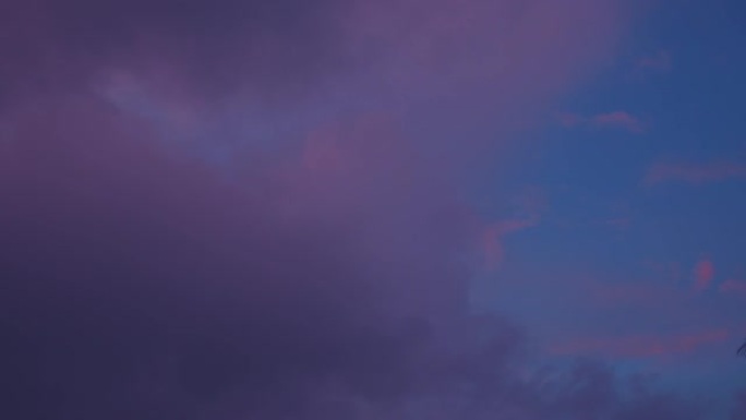 甜美的粉红色云，紫色阴影漂浮在蓝天中。