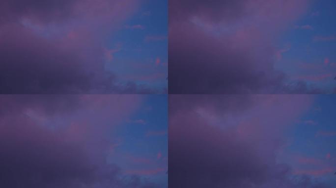 甜美的粉红色云，紫色阴影漂浮在蓝天中。