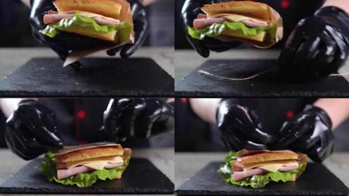 在厨房用火鸡火腿制作focaccia的过程。厨师手的特写镜头拿一个三明治，装在工艺袋里。