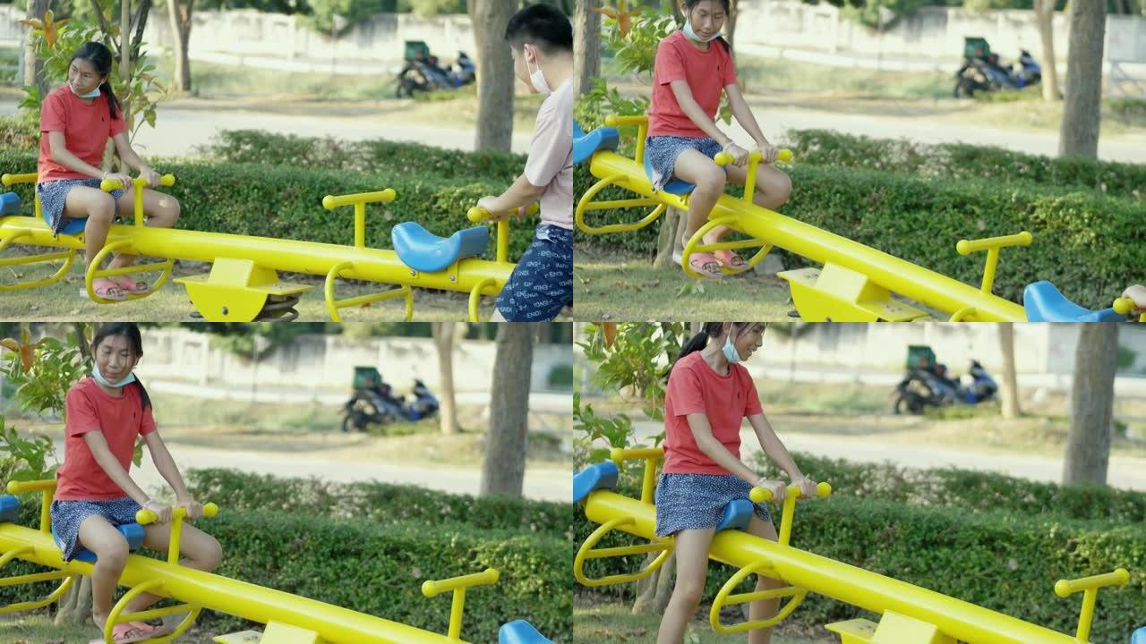 快乐的亚洲儿童在操场上一起玩跷跷板，生活方式理念。