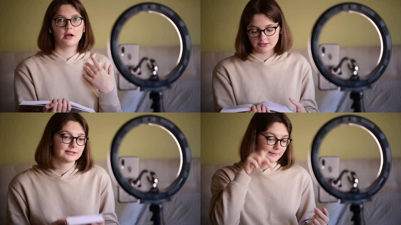 带眼镜的女孩书博客作者在数字智能手机摄像头上录制vlog