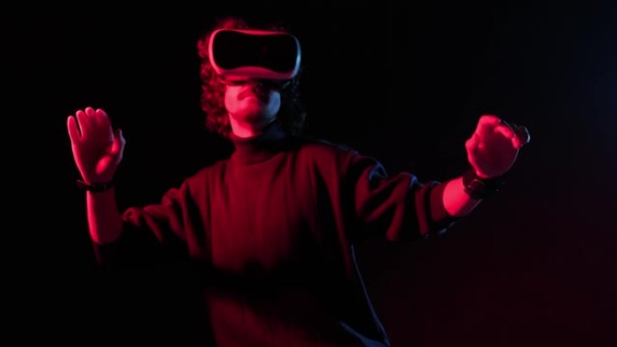 头上戴着VR头盔的男子在红蓝灯光下玩耍，在线派对