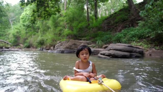 坐在山溪充气管里的亚洲小女孩