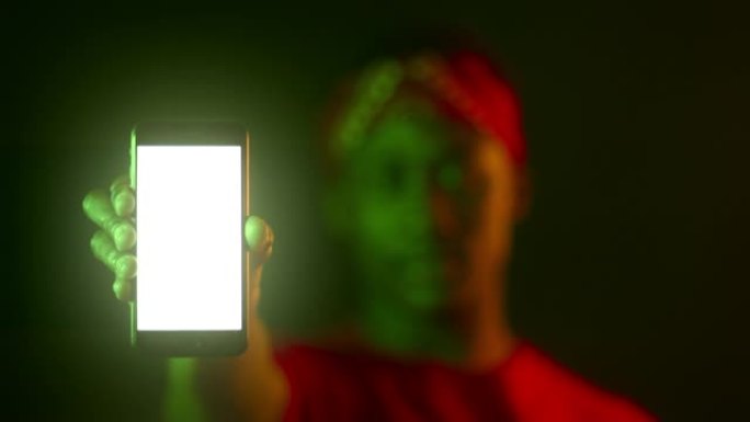 现代智能手机，黑色男性手中的空白色屏幕，霓虹灯中模糊的非洲裔美国人肖像