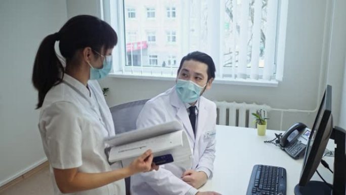 日本女护士和男医生讨论电脑屏幕后工作