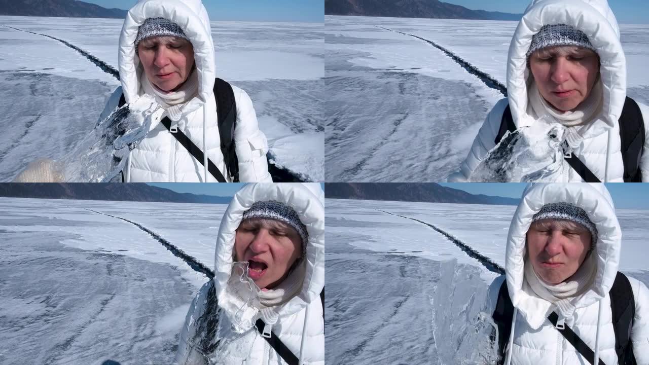 俄罗斯贝加尔湖上，一名中年妇女在一块冰面上咬一口。冰既干净又安全。