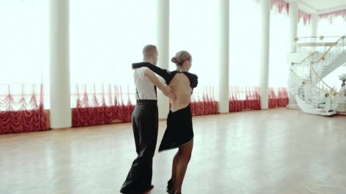 两个专业舞者在地板上跳舞。风格探戈与杂技元素