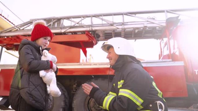 消防卫兵在车站给一个小女孩一个玩具