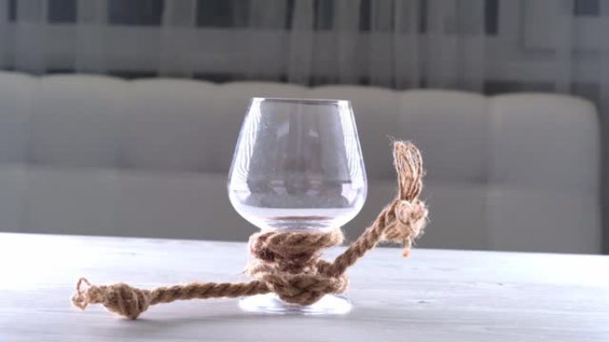 空酒杯用黄麻绳绑着。酒精依赖的概念