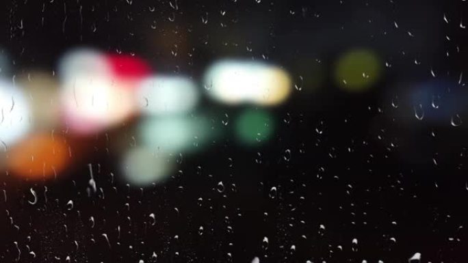 下雨时汽车前灯的灯。从窗户看。