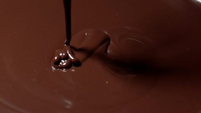 慢动作混合，用搅拌器搅拌高级黑融化的巧克力，制作糖果的过程