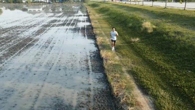 年轻的亚洲男子在早晨奔跑，空中无人机视图