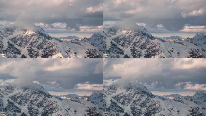 从4000米高高的雪山岩石的高度延迟，冰川和高加索主岭的山脉，傍晚的日落橙色云和山顶上的冰川。