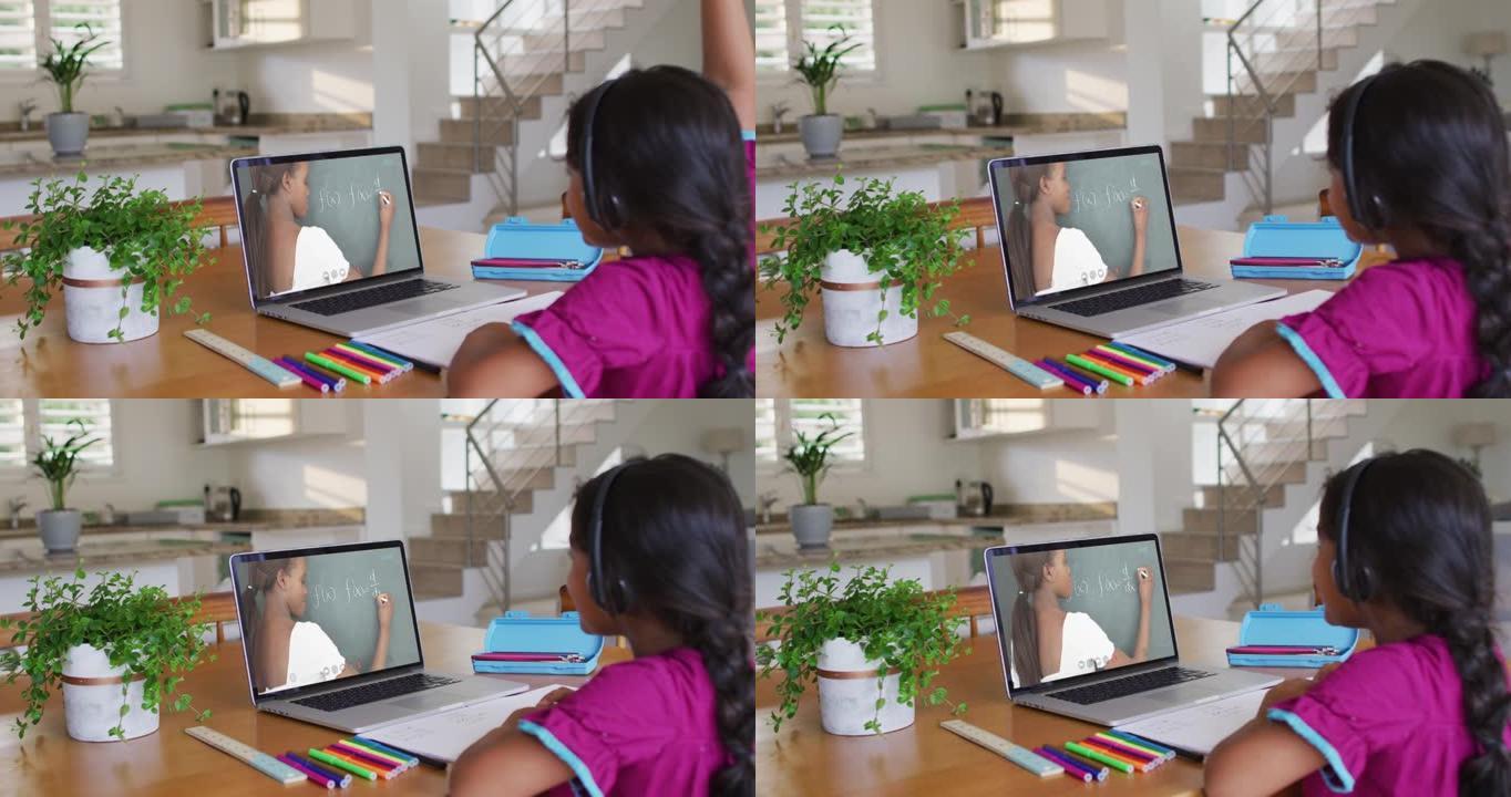 非裔美国女孩在家里的笔记本电脑上与女教师进行视频通话时举起了手
